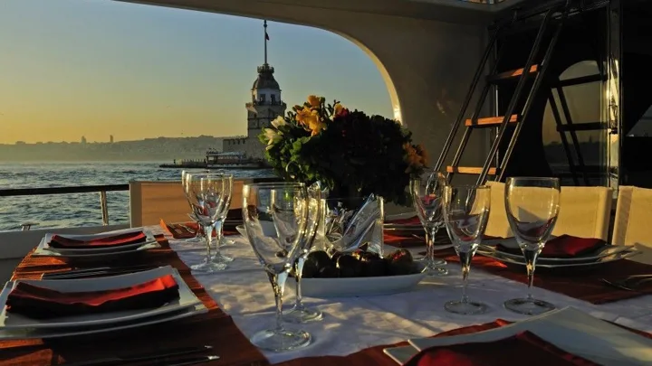Dinner table on a yacht with Maiden’s Tower beyond the window